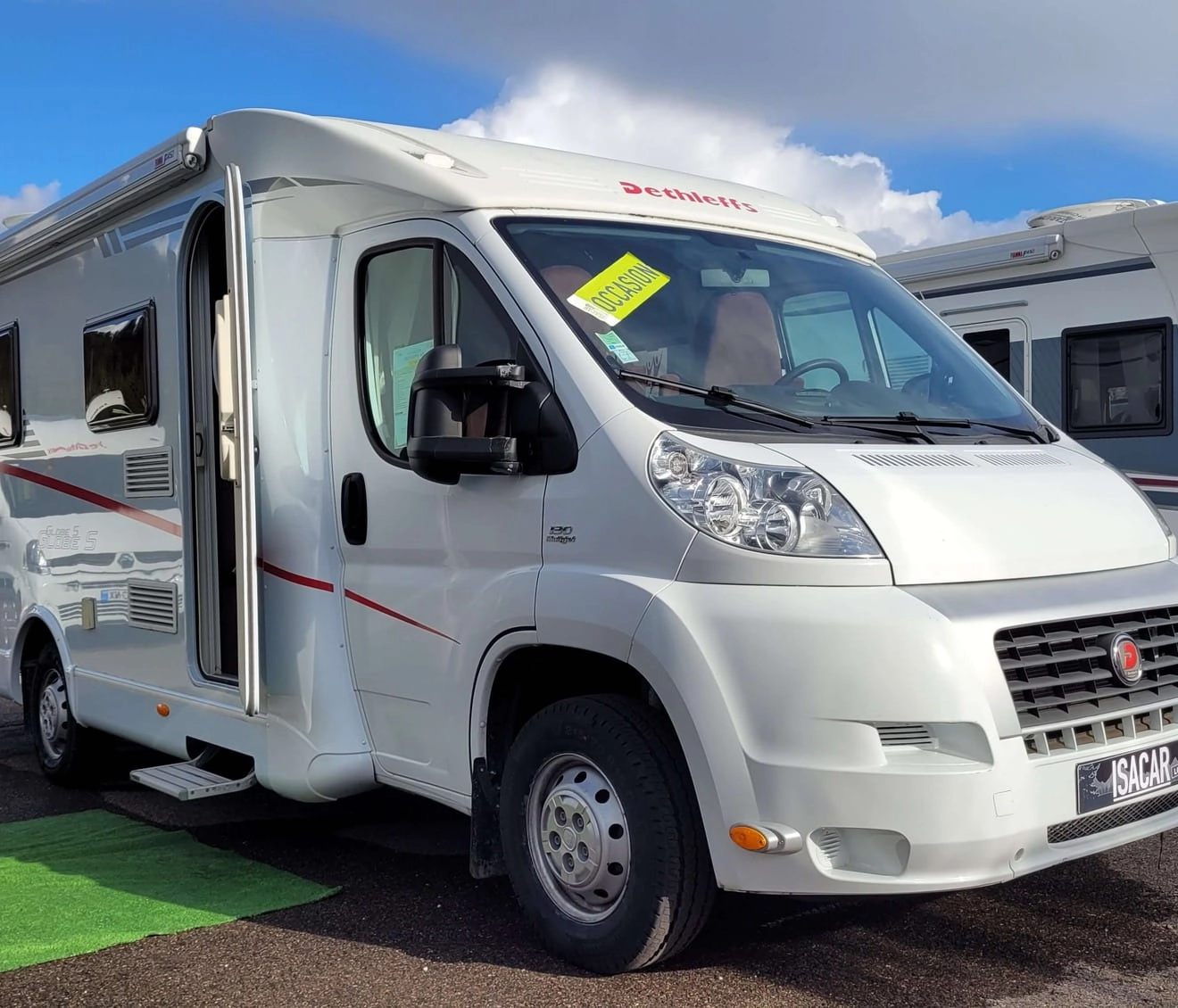 Camping-car blanc Dethleffs en vente sur un parking extérieur.