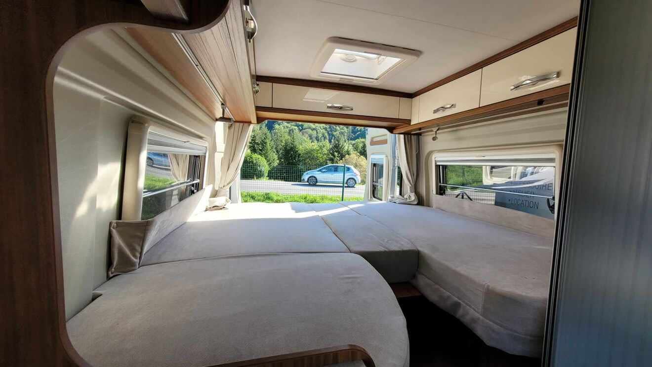 Intérieur d'un camping-car avec lit double et vue sur la route
