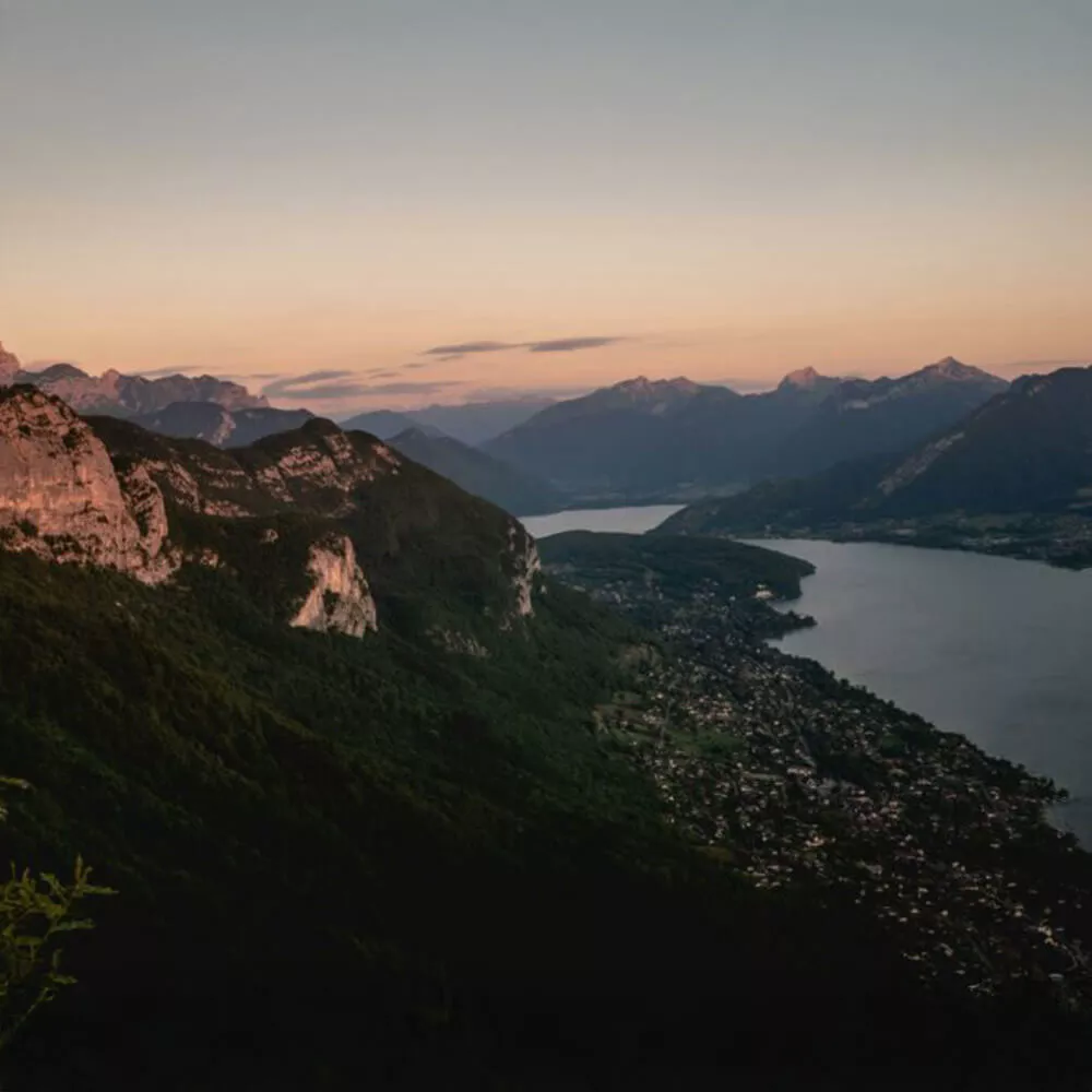 Vue aérienne du lac entouré de montagnes au coucher du soleil
