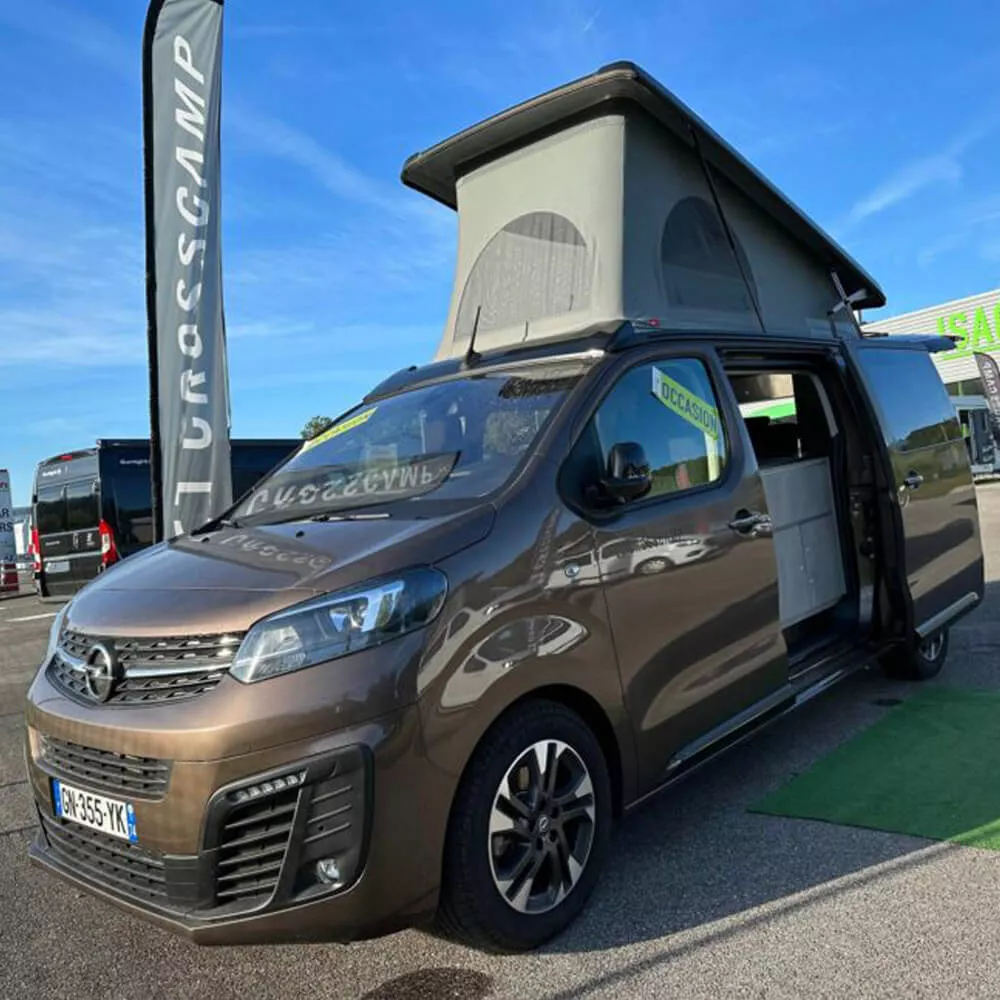 Van aménagé marron avec toit relevable en exposition chez Urosscamp