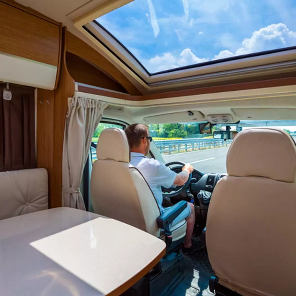Conducteur au volant d'un camping-car sur autoroute ensoleillée