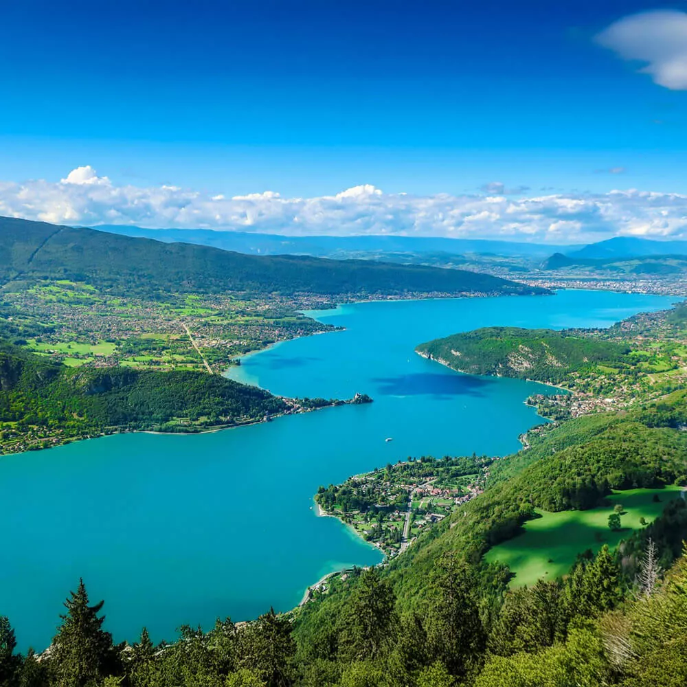 Vue aérienne du lac entouré de montagnes et de forêts verdoyantes