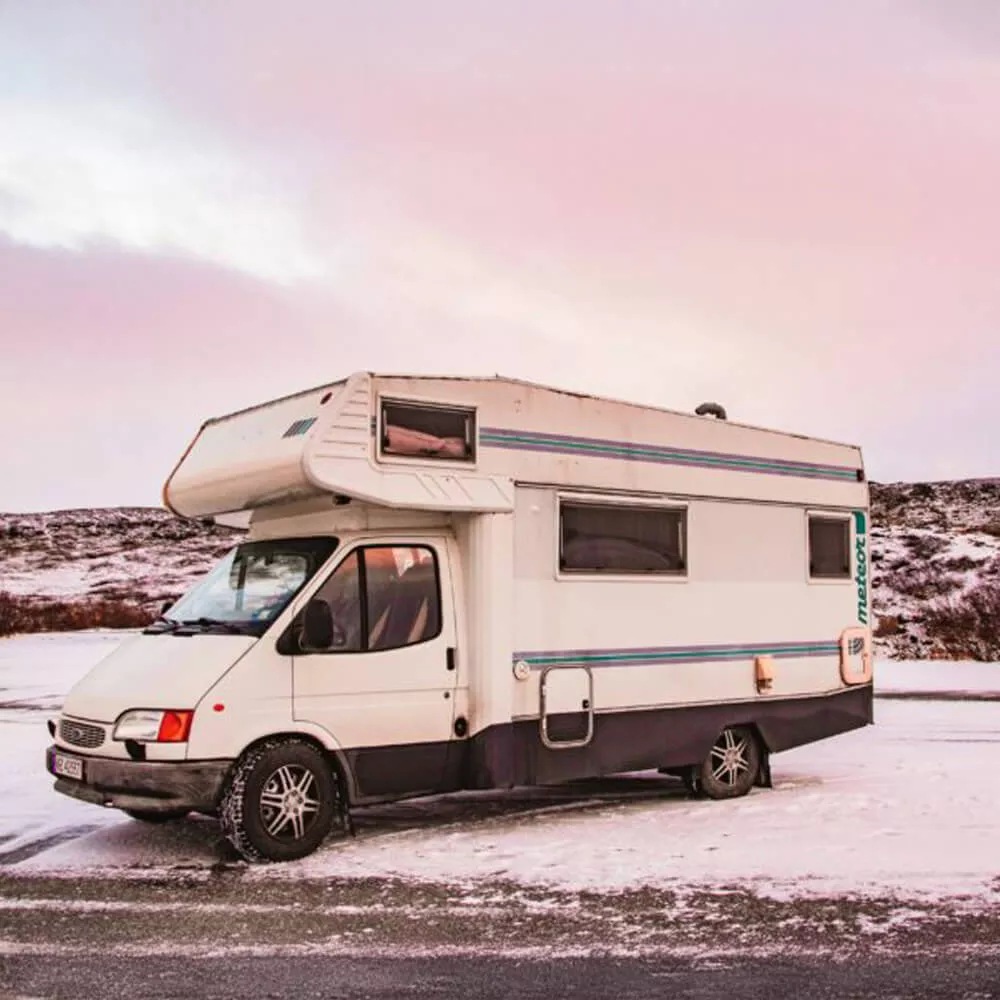 Camping-car stationné sur route enneigée au crépuscule