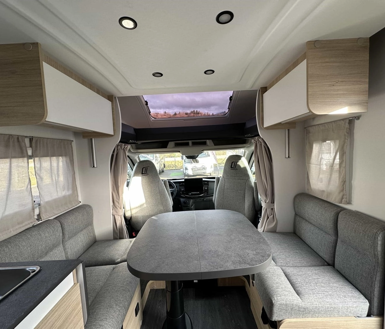 Intérieur d'un camping-car moderne avec table et banquettes grises