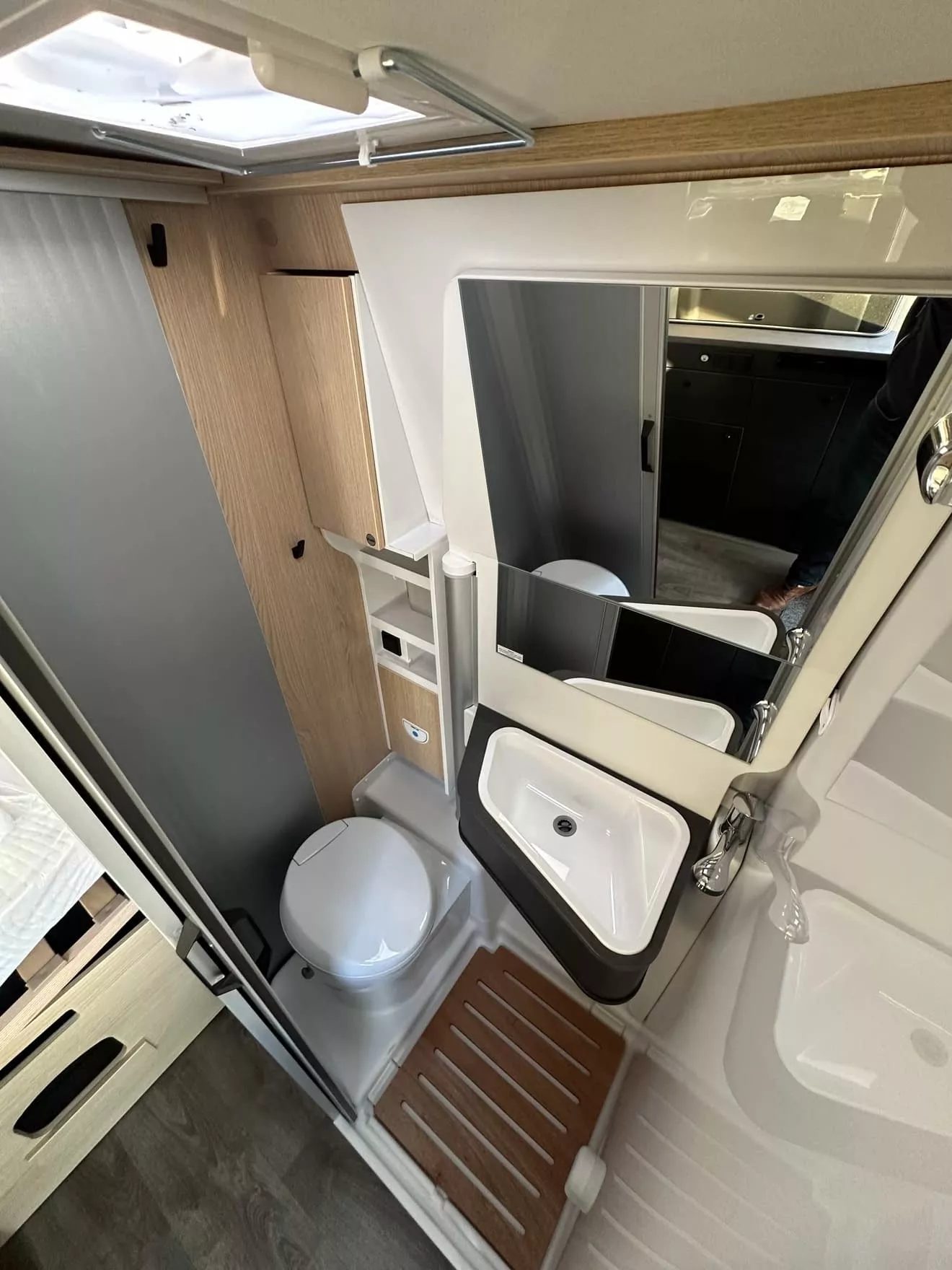 Salle de bain compacte dans un camping-car moderne avec lavabo et toilettes.