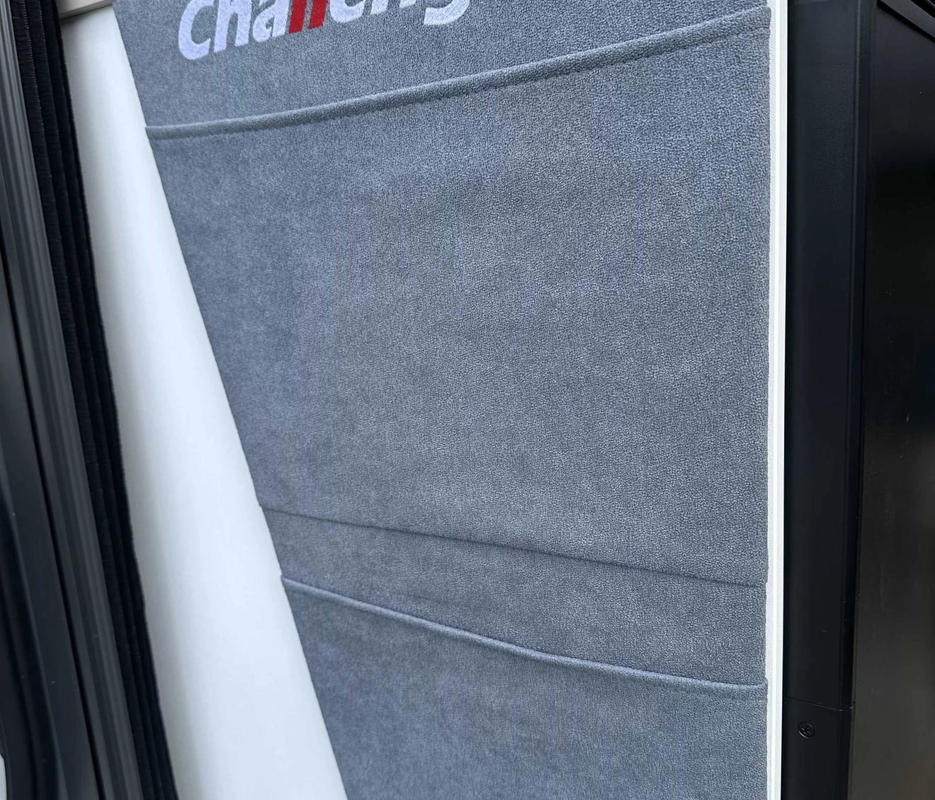 Porte de réfrigérateur avec housse grise et logo Challenger visible