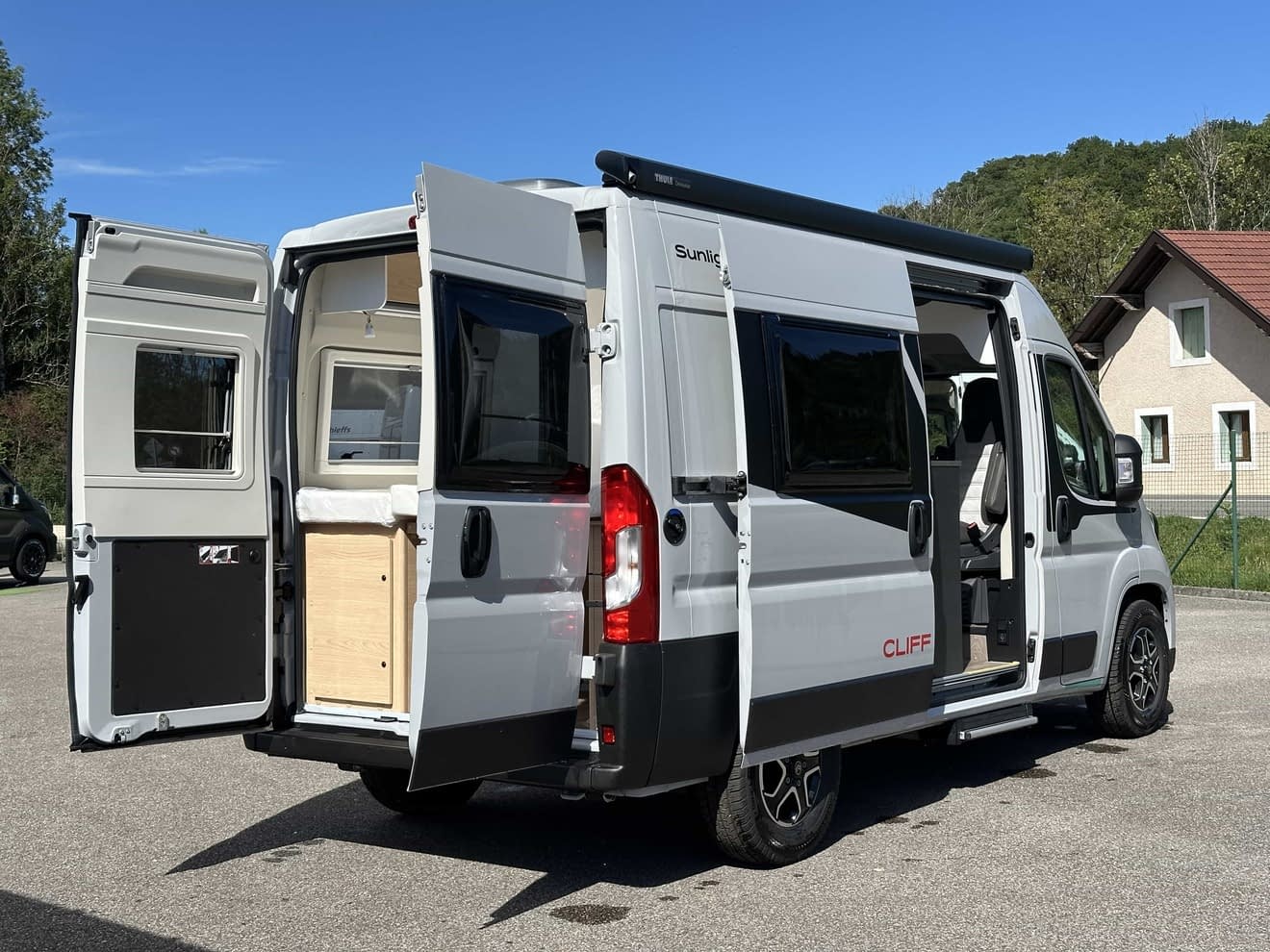 Fourgon aménagé Sunlight Cliff avec portes ouvertes sur parking