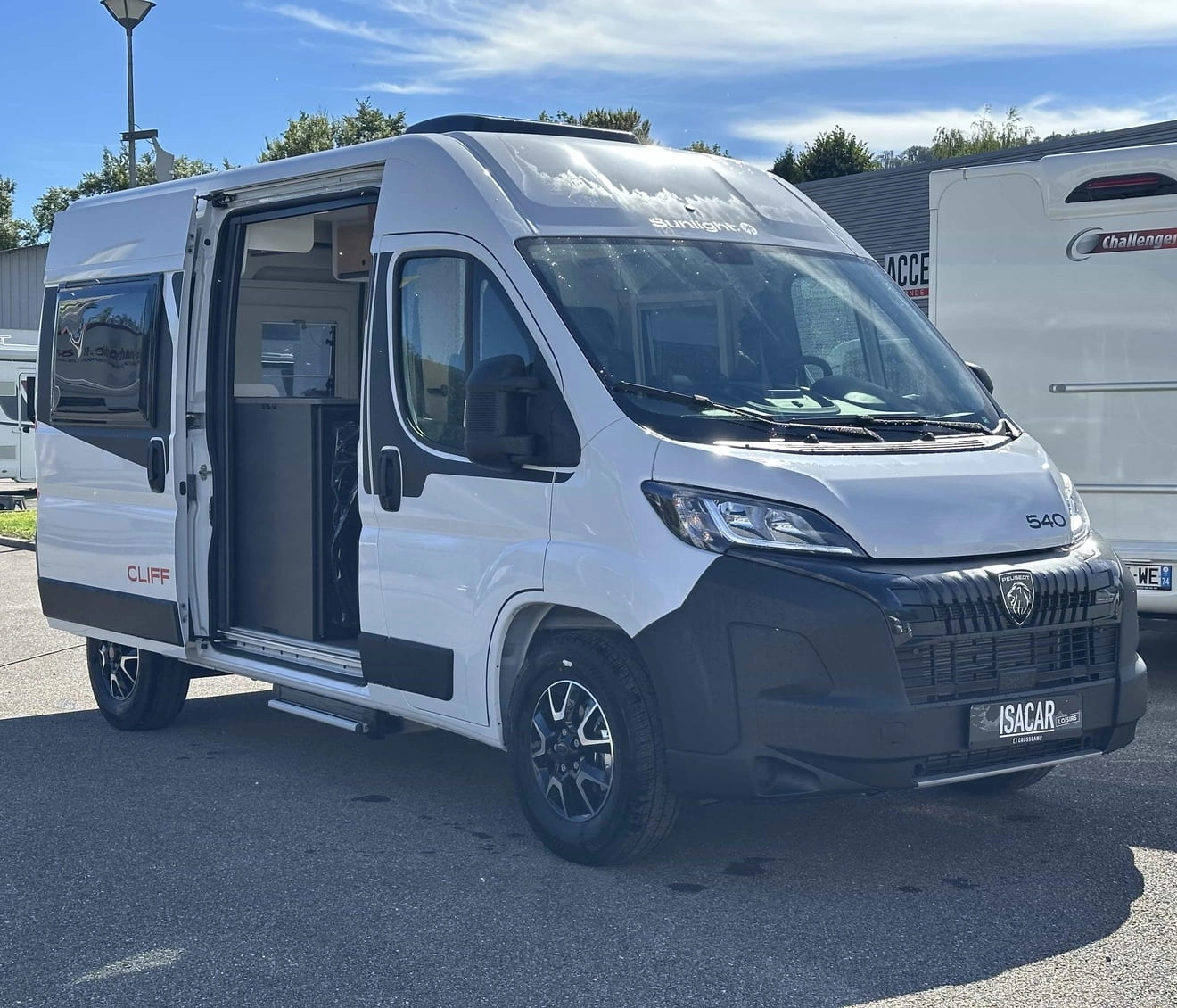Fourgon aménagé Sunlight Cliff 540 stationné sur un parking, porte latérale ouverte