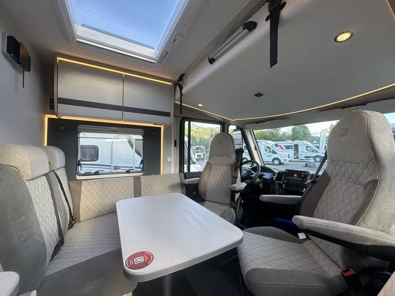 Intérieur d'un camping-car moderne avec sièges et table, éclairage LED