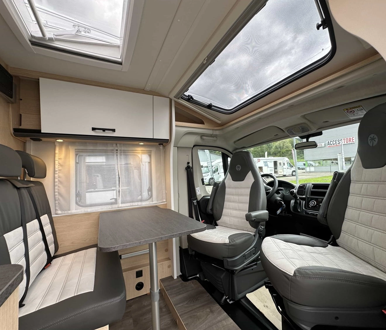 Intérieur moderne d'un camping-car avec sièges et table.