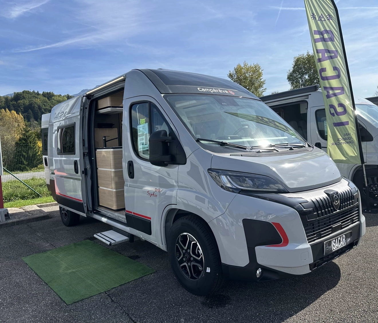 Fourgon aménagé Camperêve garé sur un parking, porte latérale ouverte