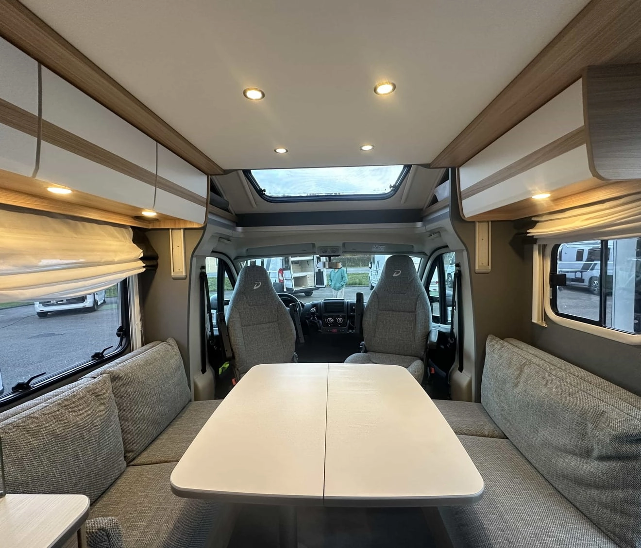 Intérieur d'un camping-car moderne avec table et sièges gris
