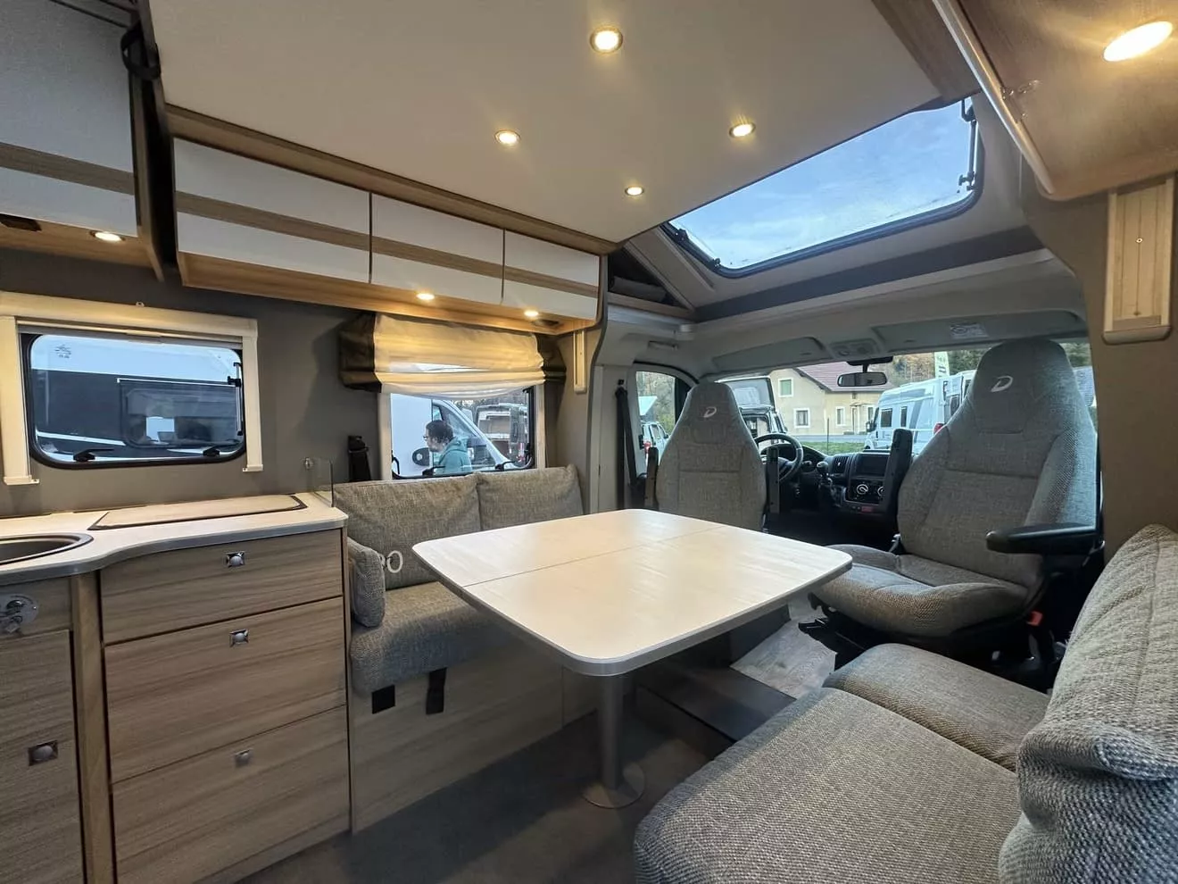 Intérieur d'un camping-car moderne avec table et sièges en tissu gris