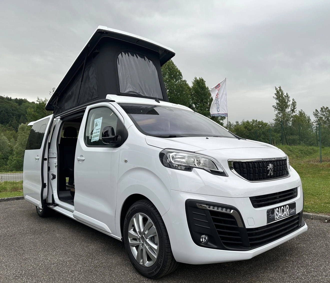 Van Peugeot blanc avec toit relevable sur un parking