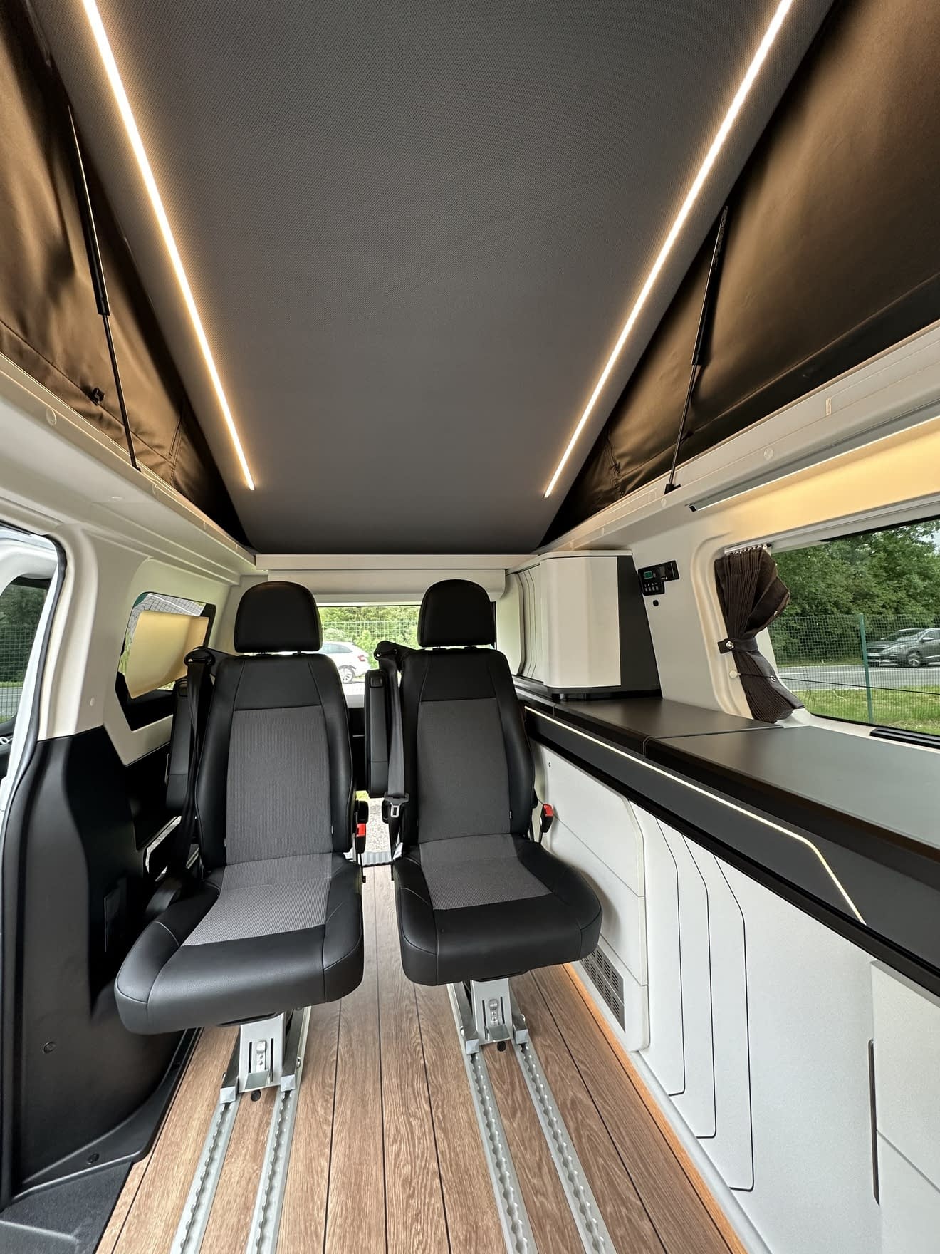 Intérieur d'un van aménagé avec sièges pivotants et éclairage LED