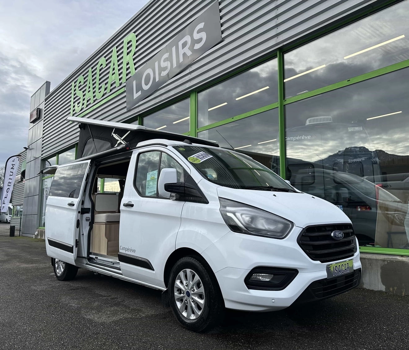 Camping-car blanc devant le magasin Isacar Loisirs