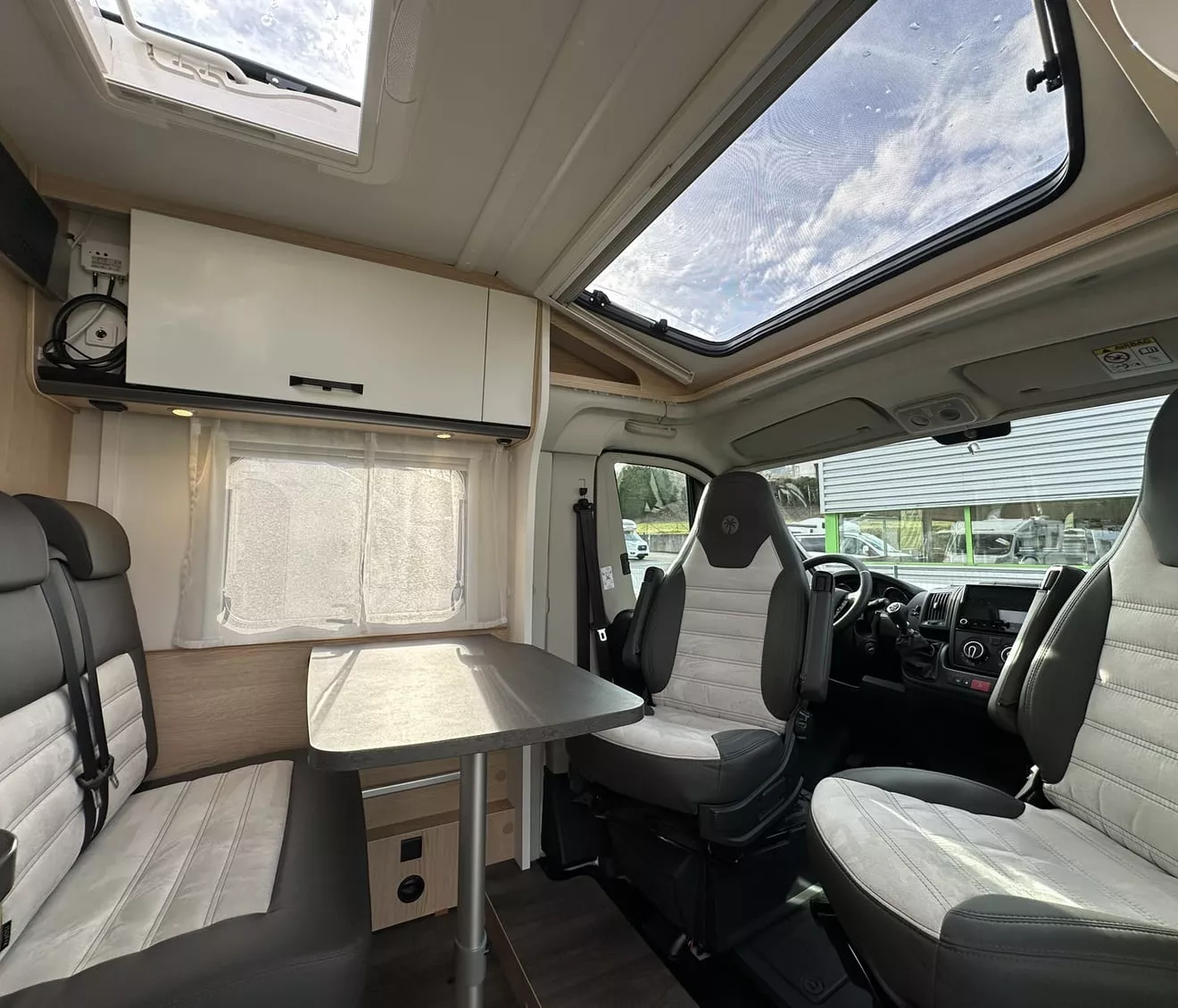 Intérieur d'un camping-car moderne avec sièges et table.