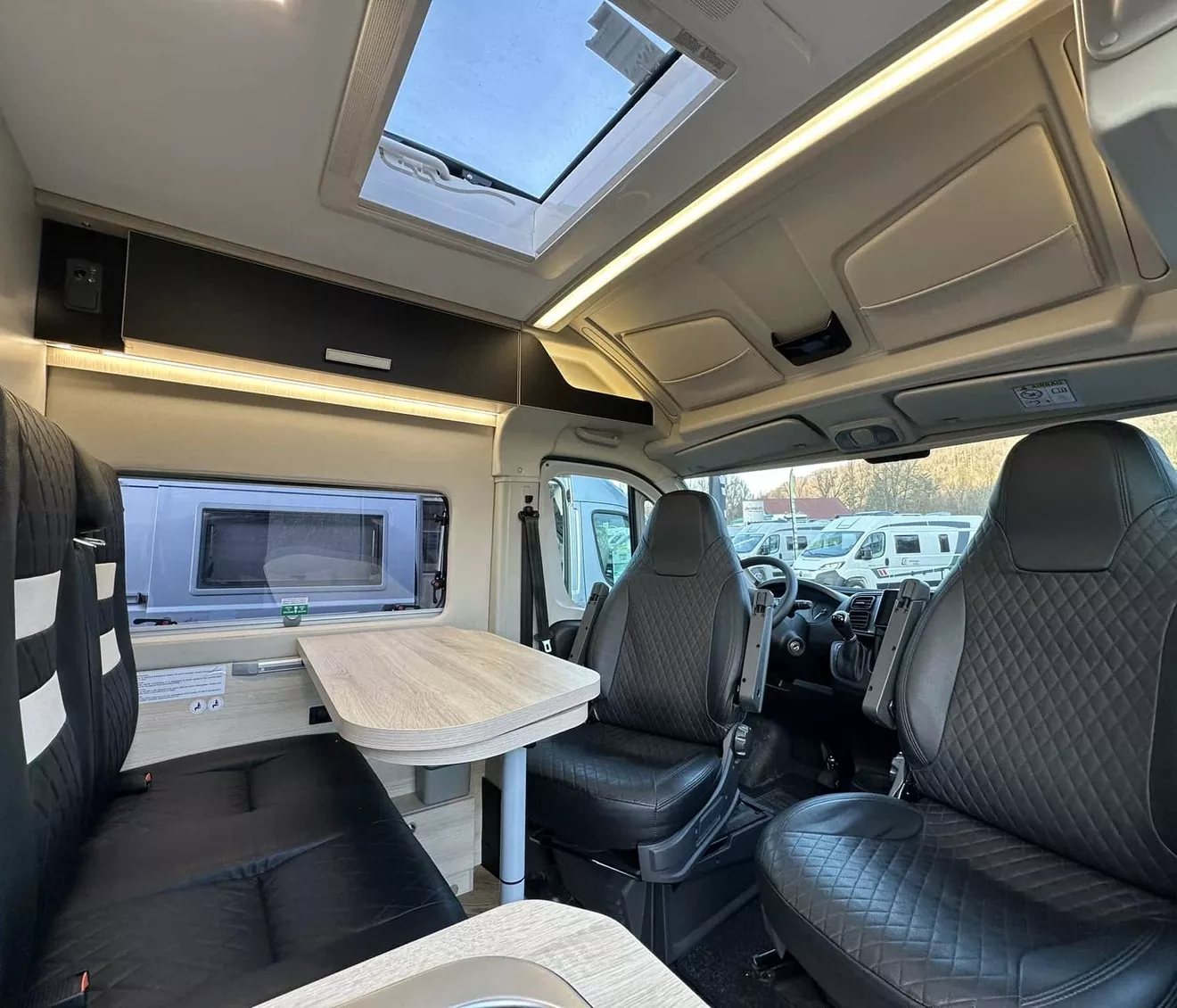 Intérieur d'un camping-car moderne avec sièges en cuir et table pliante