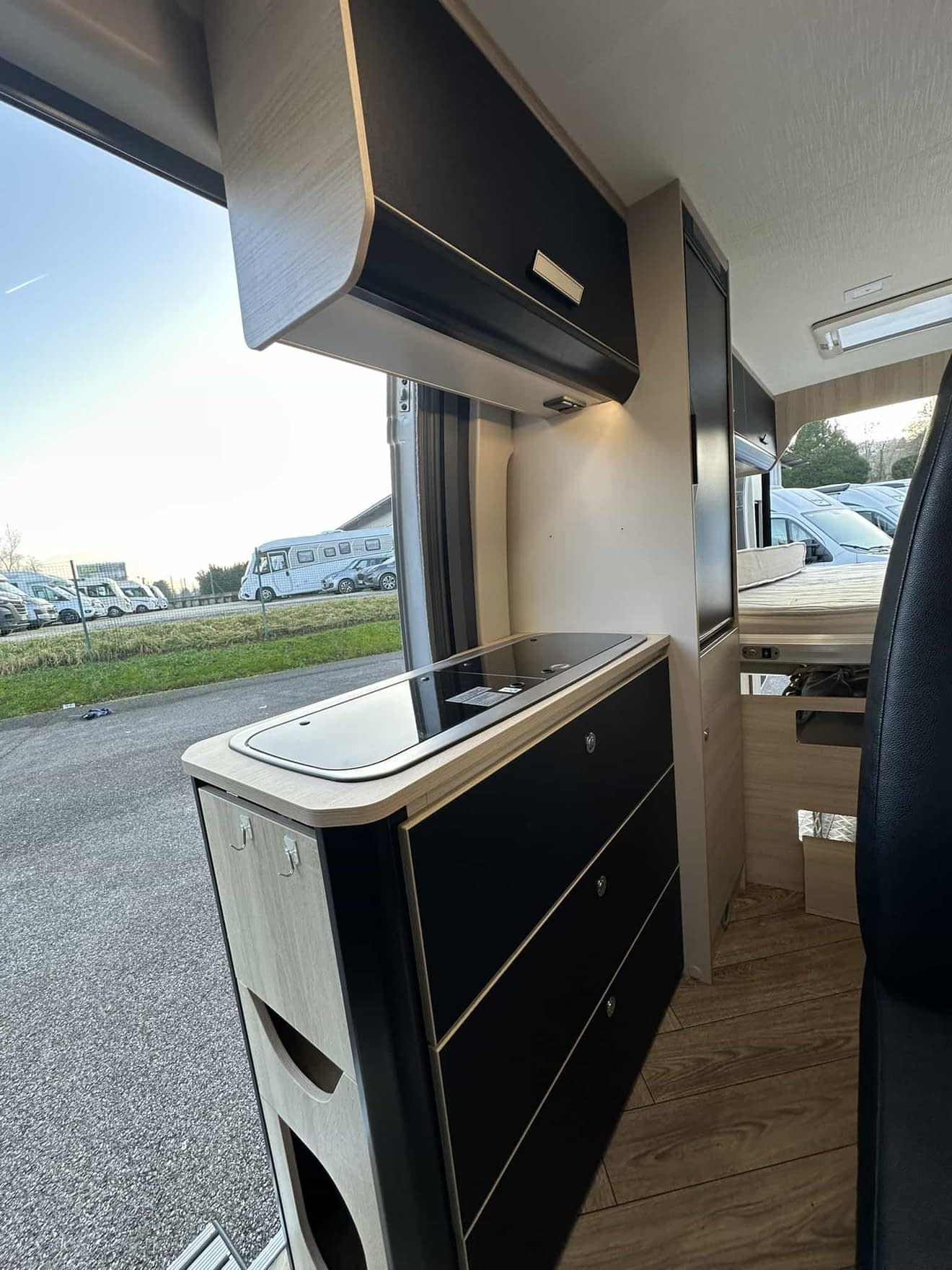 Intérieur moderne d'un camping-car avec cuisine équipée et rangements.