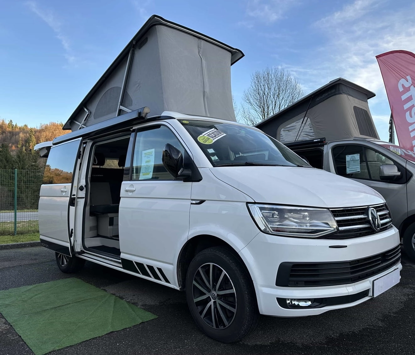 Van aménagé blanc avec toit relevable en exposition extérieure