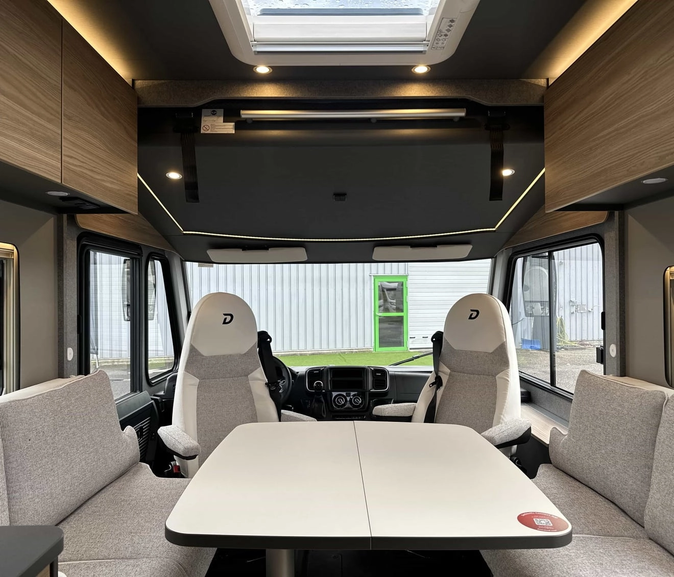 Intérieur d'un camping-car moderne avec table et sièges en tissu gris