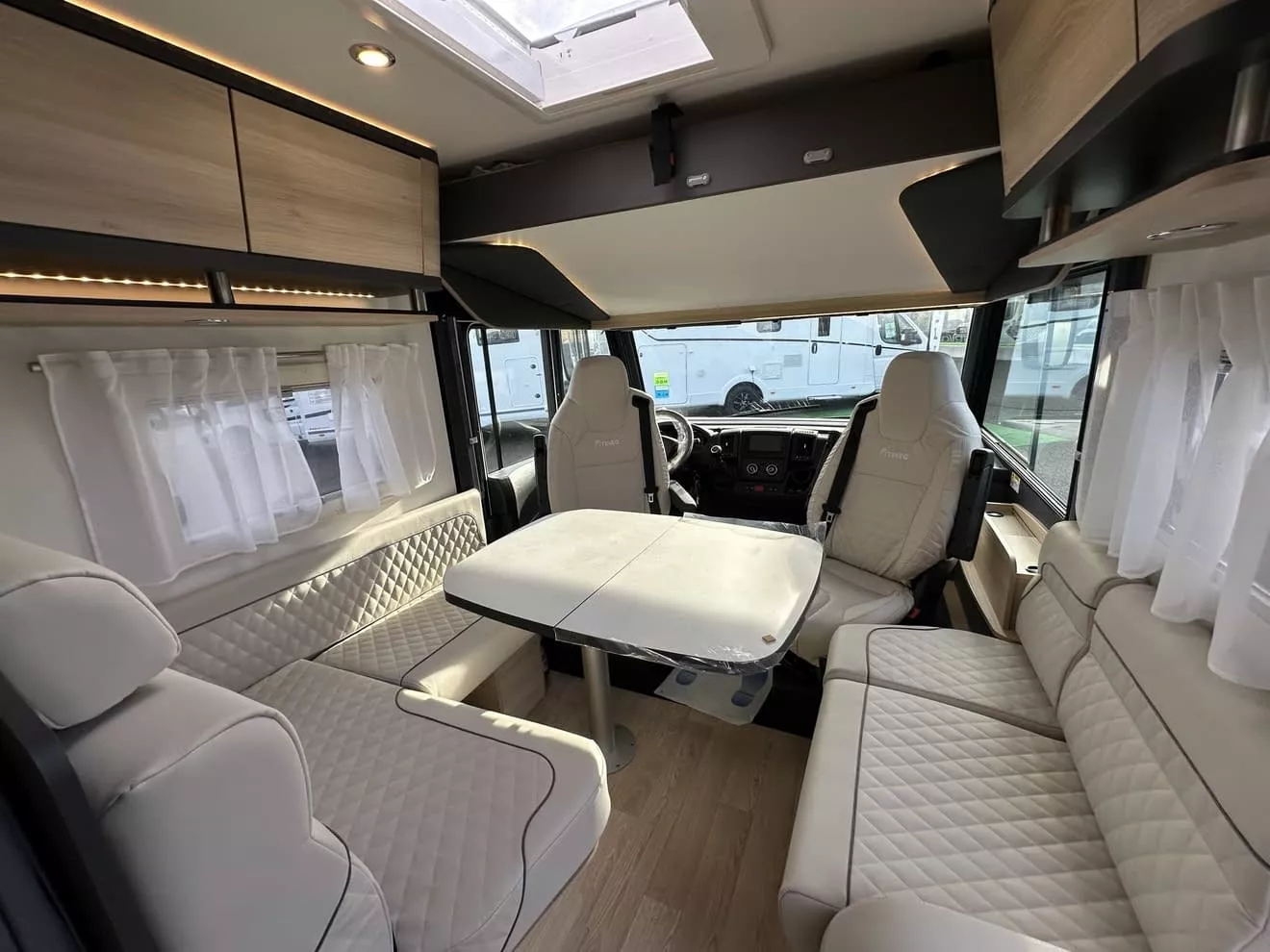 Intérieur d'un camping-car moderne avec sièges en cuir et table pliante