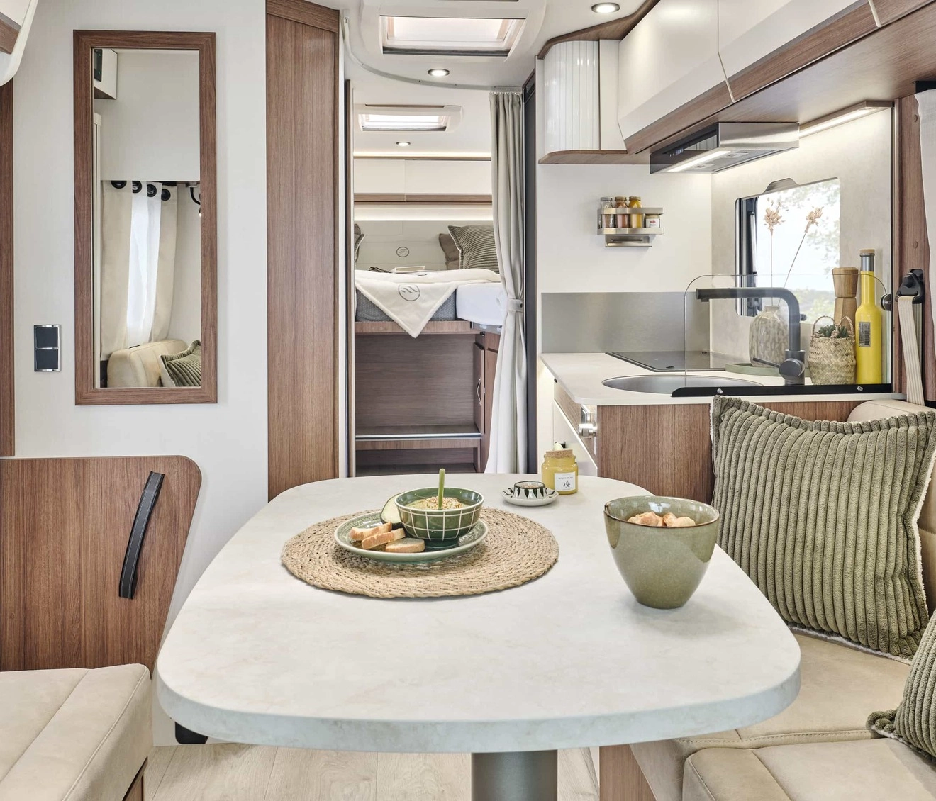 Intérieur moderne de camping-car avec cuisine et coin repas.