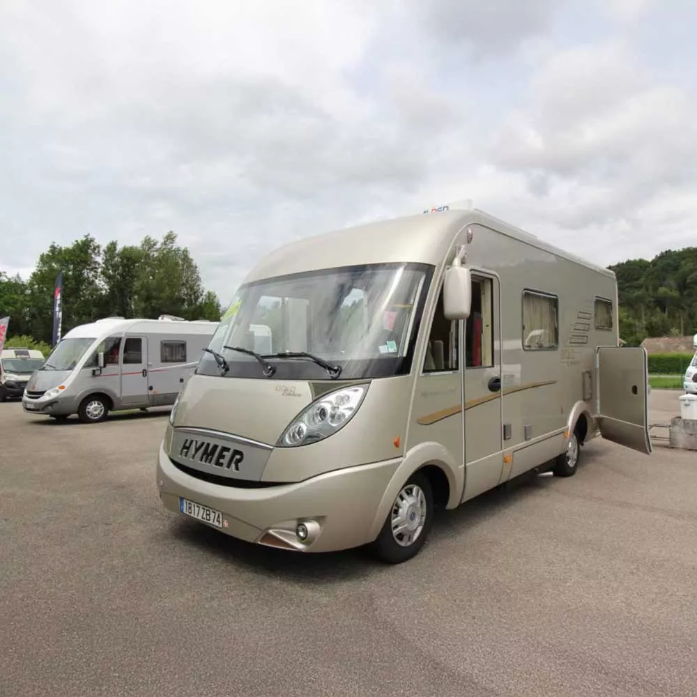 Camping-car Hymer stationné sur un parking, ciel nuageux en arrière-plan